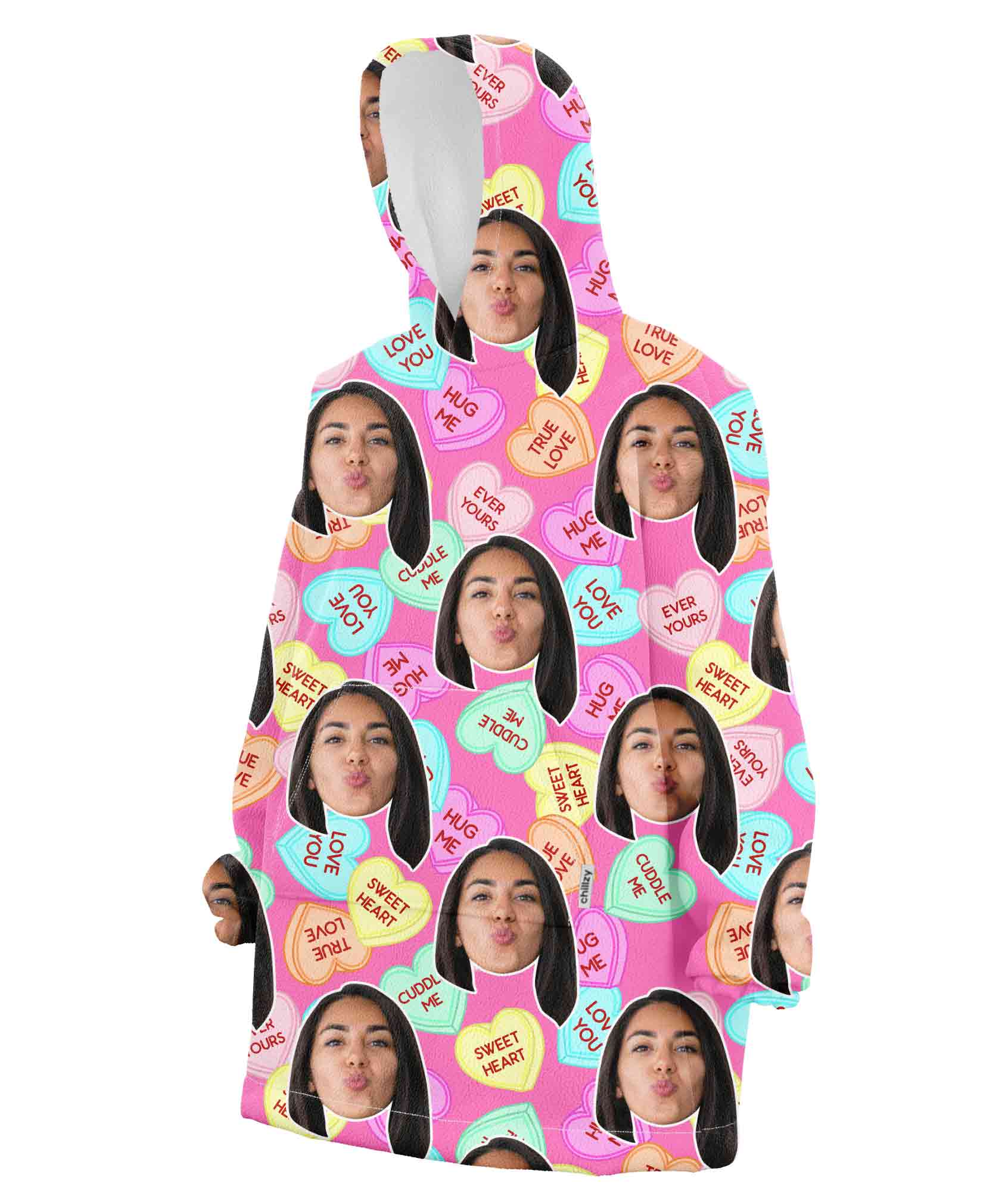A hooded blanket with a pattern of a young girl's face and text 'Love You' displayed across a pink background with multicolored hearts.