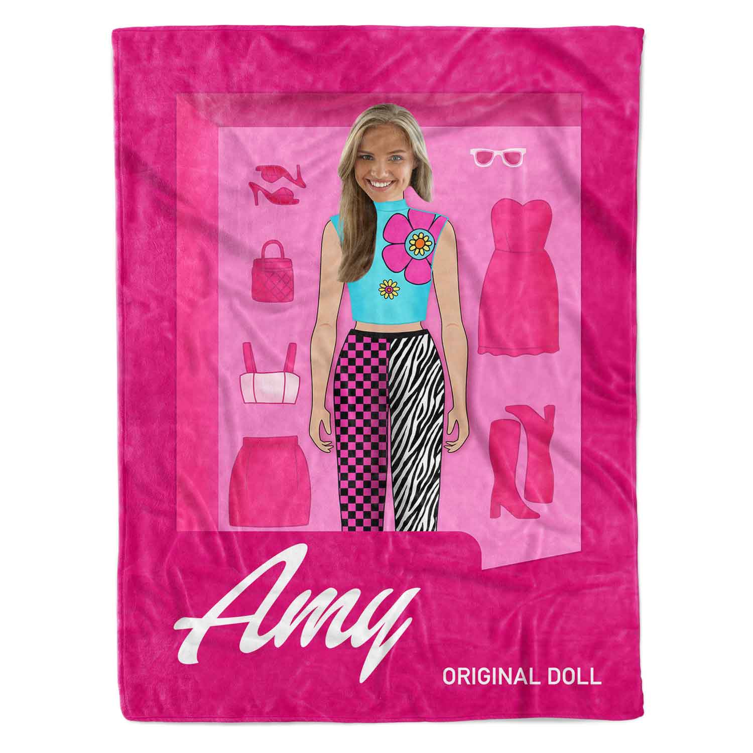 Pink blanket with a paper doll and fashion items on a white background