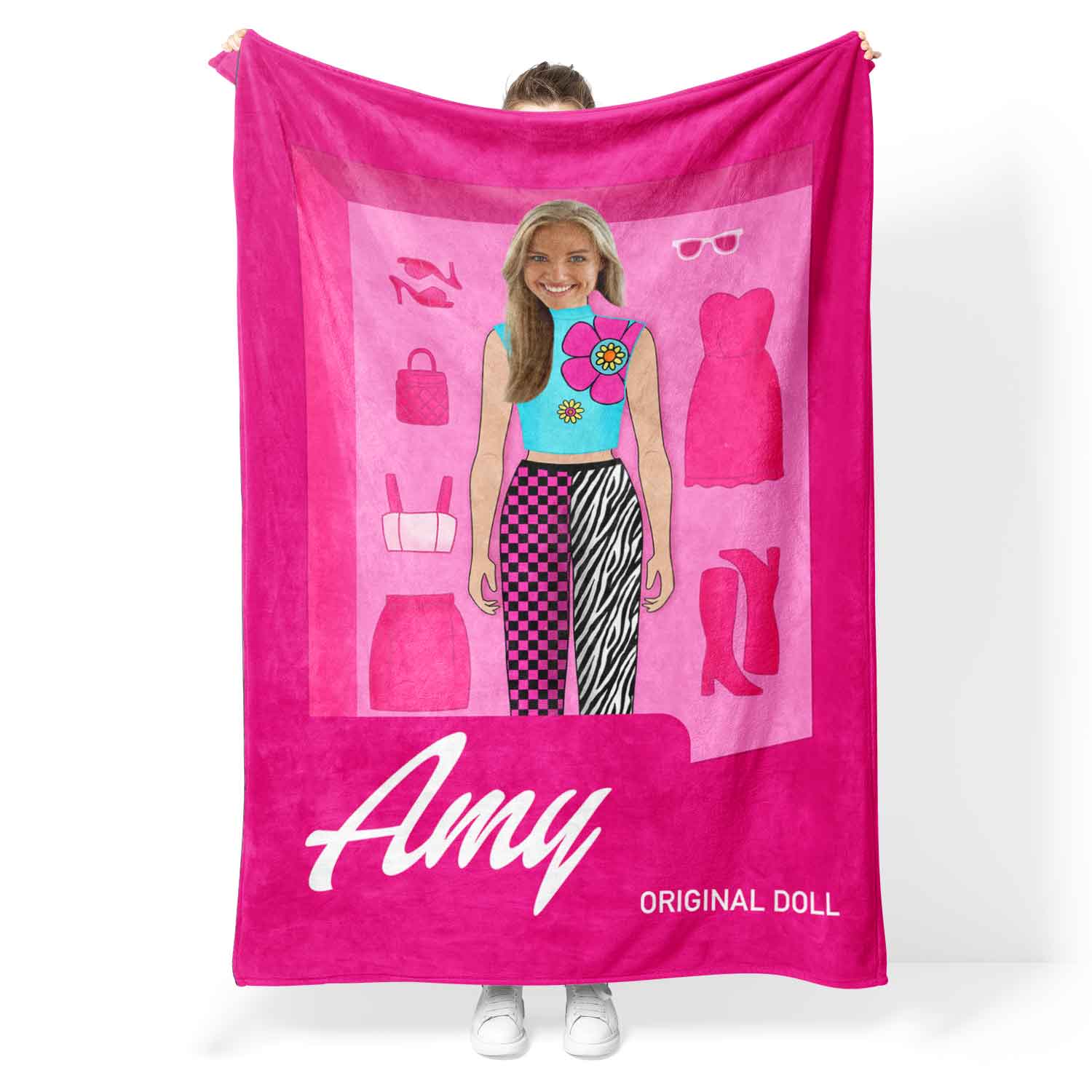 Pink towel with a graphic of a girl and clothing items, held by a person.
